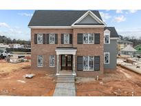 New construction brick home featuring black shutters, gray roof, covered front porch and stone walkway at 2623 Marchmont St, Raleigh, NC 27608