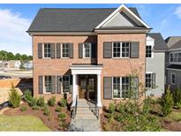 Charming brick home with black shutters, manicured landscaping, and welcoming front entrance at 2623 Marchmont St, Raleigh, NC 27608