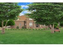 Charming brick home featuring a beautifully manicured lawn and mature trees for added curb appeal at 296 Shoreline Dr, Princeton, NC 27569