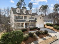 Charming two-story home featuring a welcoming front porch, attached two-car garage, and lush landscaping at 3732 Coach Lantern Ave, Wake Forest, NC 27587