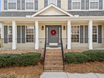 Charming home entrance featuring a welcoming wreath and a brick stairway leading to the front door at 3732 Coach Lantern Ave, Wake Forest, NC 27587
