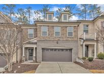 Charming townhome with stone and brick facade, two-car garage, and well-maintained landscaping at 410 Bent Tree Ln, Cary, NC 27519
