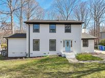 Charming two-story home featuring a classic white brick exterior and a light blue front door at 5704 Whippoorwill St, Durham, NC 27704