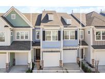 Charming townhome featuring light blue siding, a one-car garage, and well-maintained landscaping at 624 Metro Station, Apex, NC 27502