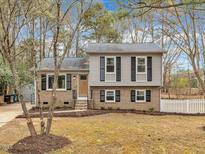 Charming two-story home with a brick and vinyl exterior, complemented by a well-manicured lawn and mature trees at 1041 Limerick Ln, Durham, NC 27713