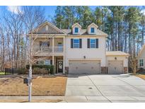 Charming two-story home featuring a welcoming front porch and a three-car garage at 1103 River Birch Way Way, Mebane, NC 27302