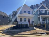 Charming two-story home with a red door, white trim, and a welcoming front porch on a sunny day at 122 Weavers Grove Dr, Chapel Hill, NC 27514