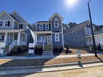 Charming two-story home featuring a welcoming front porch and a beautifully landscaped yard under a bright blue sky at 138 Weavers Grove Dr, Chapel Hill, NC 27514