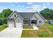 Charming single-Gathering home boasts a two-car garage, welcoming front porch, and a well-manicured lawn at 1604 Palmer Dr, Graham, NC 27253