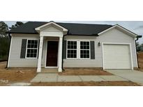 Charming single-story home featuring light siding, dark shutters, a garage, and a well-manicured lawn at 272 Johnson Ridge Way, Four Oaks, NC 27524