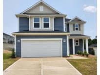 Two-story home featuring a two-car garage, blue siding, and a well-manicured lawn at 28 Longdale Dr, Graham, NC 27253