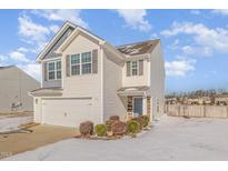 Charming two-story home featuring vinyl siding, an attached garage, and neatly trimmed landscaping at 310 Mineral Spring Ln, Fuquay Varina, NC 27526