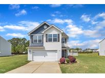 Charming two-story home featuring white siding, a front-facing garage, and well-manicured landscaping at 310 Mineral Spring Ln, Fuquay Varina, NC 27526