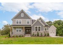Charming two-story home featuring stone accents, a welcoming porch, and attached garage at 4225 Burlington Mills Rd, Wake Forest, NC 27587