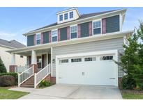 Two-story home featuring a two-car garage and charming front porch with brick foundation and white columns at 4508 Brintons Cottage St, Raleigh, NC 27616