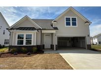 Charming new construction home with light siding, a covered front porch, and a spacious two-car garage at 720 Hipwood Dr, Zebulon, NC 27597