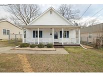 Charming single-story home featuring a cozy front porch with stylish blue shutters, complemented by a well-maintained lawn at 847 Estes St, Durham, NC 27701