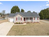 Charming one story home featuring red shutters, inviting porch, and a well-maintained front lawn at 913 S Willhaven Dr, Fuquay Varina, NC 27526
