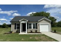 Charming single-story home with vinyl siding, black shutters, and a well-manicured front yard at 114 Johnson Ridge Way, Four Oaks, NC 27524