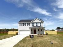 New two-story home featuring a white siding, black shutters, a front-entry two-car garage, and a well-manicured lawn at 120 Whistling Way # Cary Traditiol, Lillington, NC 27546