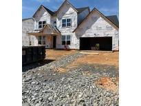 Unfinished exterior showing the frame of the house and two-car garage with front yard still under construction at 1204 Opal Ln # 93, Durham, NC 27705