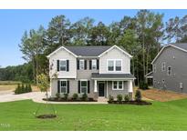 Charming two-story home with gray siding, black shutters, and a well-manicured lawn at 1803 Ballard Rd # Holly Craftsman, Fuquay Varina, NC 27526