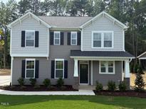 Charming two-story home with gray siding, black shutters, and a well-manicured lawn at 1803 Ballard Rd # Holly Craftsman, Fuquay Varina, NC 27526