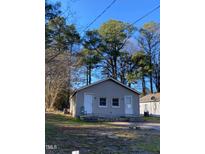 Cozy gray home featuring two front doors and surrounded by mature trees at 207 Booth Ave, Henderson, NC 27536