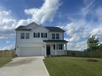 Charming two-story home with a garage, a well-maintained lawn, and a wooden fence at 22 Whistling Way # Holly Farmhouse, Lillington, NC 27546