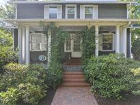 Charming home featuring a welcoming front entrance with lush greenery and a brick pathway at 230 E Park Dr, Raleigh, NC 27605