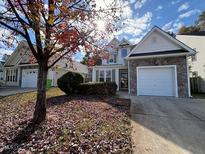 Charming two-story home with stone accents, attached garage, and tree-lined front yard at 3144 La Costa Way, Raleigh, NC 27610