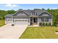 Charming home featuring a three-car garage and professionally landscaped front yard at 40 Cinnamon Teal Way, Youngsville, NC 27596