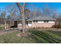 Charming single-story brick home with a covered carport, front porch, and a well-maintained lawn at 413 Hocutt Rd, Durham, NC 27703