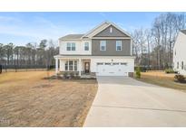 Charming two-story home boasts a welcoming two-car garage and a well-maintained front yard at 474 W Ravano Dr, Clayton, NC 27527