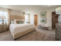 Spacious bedroom features a tufted headboard, neutral tones, and ensuite bathroom access at 505 Marthas View Way, Wake Forest, NC 27587
