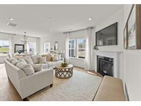Bright living room with a fireplace, large sofa, and an ornate coffee table at 509 Marthas View Way, Wake Forest, NC 27587