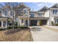 Charming townhome featuring a beige exterior, attached garage, and well-manicured landscaping at 510 Mariah Towns Way, Garner, NC 27529