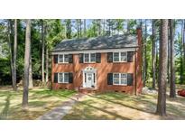 Charming two-story brick home with a well-manicured lawn and mature trees at 636 Palmer Dr, Sanford, NC 27330