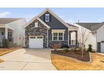 Charming home featuring stone accents, a one-car garage, landscaped yard, and a covered front entry at 1215 White Flint Cir, Durham, NC 27703
