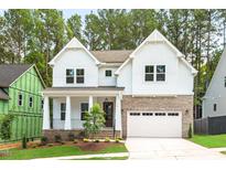 Charming two-story home with a brick and siding exterior, covered front porch, and attached two-car garage at 122 Sanderway Dr, Chapel Hill, NC 27516