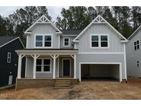 Charming two-story home with a covered porch, an attached two-car garage, and stylish gray siding at 122 Sanderway Dr, Chapel Hill, NC 27516