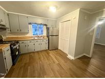 This cozy kitchen has stainless steel appliances, wood countertops and modern gray cabinets at 128 Warren Ave, Oxford, NC 27565