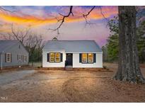 Charming home featuring a metal roof, neutral siding and black accent shutters, nestled on a large lot at 1304 S 14Th St, Lillington, NC 27546