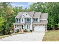 Charming two-story home with stone accents, a welcoming porch, and an attached two-car garage at 1354 Red Bud Ct, Wake Forest, NC 27587