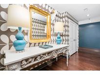 Hallway featuring a unique wallpaper pattern, hardwood floors, and ornate console table with elegant lamps at 140 W Franklin St # 406, Chapel Hill, NC 27516