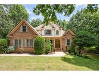 Charming brick two-story home with a well-manicured lawn and mature trees at 155 Georgetown Woods Dr, Youngsville, NC 27596