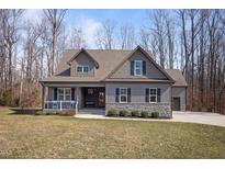 Charming home featuring a stone accent base, gray siding, dormers, and a welcoming front porch at 193 Jenny Ln, Timberlake, NC 27583