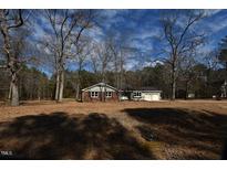 Charming single-story home with brick and gray siding nestled on a large lot with mature trees at 203 Alpine Way, Clayton, NC 27527