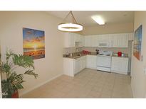 Well-lit kitchen featuring white cabinets, granite countertops, and a tile floor, offering a clean and functional space at 2520 Friedland # 202, Raleigh, NC 27617