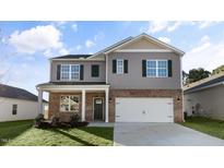 Charming two-story home with gray siding, brick accents, and a well-manicured lawn at 2562 Summersby Dr, Mebane, NC 27302